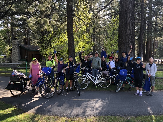 Volunteers with their bikes, trash bags and litter grabbers gathered on a Tahoe bike path for a cleanup